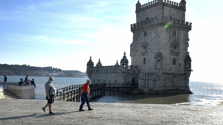 People wearing protective masks walk near the tourist zone of Torre de Belem, Lisbon, on September 08, 2020. Portugal could receive up to six different covid-19 vaccines by summer of next year. An agreement for almost seven million doses has already been signed with the pharmaceutical company AstraZeneca, but the European Union is already in advanced negotiations with five other suppliers for advance purchase of potential vaccines. (Photo by Jorge Mantilla/NurPhoto via Getty Images)