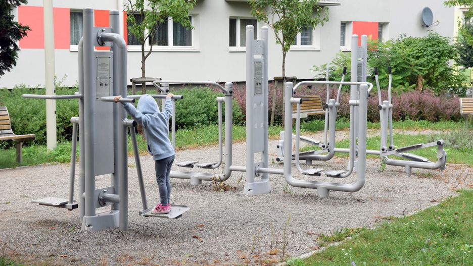 Mała dziewczynka ćwiczy w siłowni plenerowej
