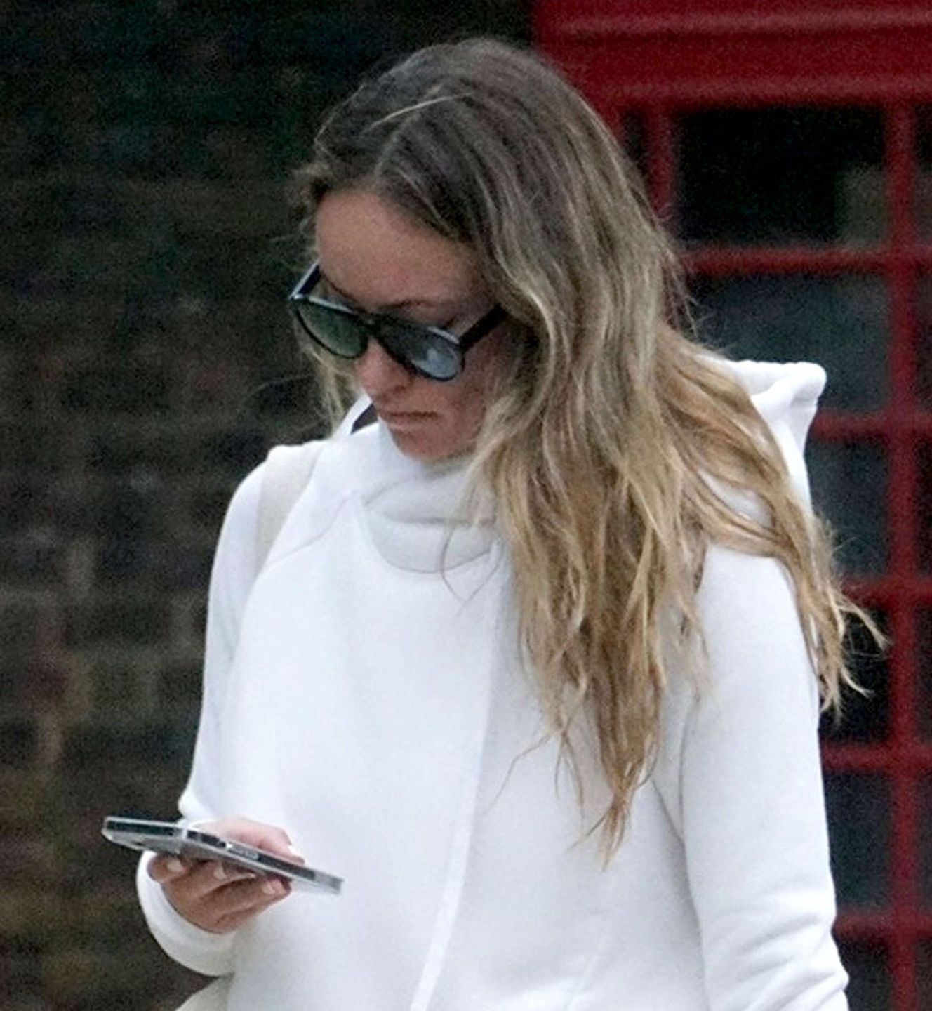 *EXCLUSIVE* The American Actress Olivia Wilde seems engrossed on her mobile phone as she takes a walk through Hampstead, North London.London, UNITED KINGDOM  -  *EXCLUSIVE*  - Harry Styles' American Actress and Girlfriend Olivia Wilde goes into casual mode as she donned her white hooded top and black jeans and seemed rather engrossed on her mobile phone as she takes a walk through Hampstead, North London.BACKGRID UK 25 MAY 2022,Image: 694393204, License: Rights-managed, Restrictions: , Model Release: no, Pictured: Olivia Wilde, Credit line: Stanley / BACKGRID / Backgrid UK / ForumStanley / BACKGRID / Backgrid UK / ForumOlivia Wilde, Black Sunglasses, Tinted Sunglasses, Makeup, Pink Lipstick, White Hoodie, White Handbag, Phone, Cell Phone, Black Jeans, Denim, Black Boots, Smile, Funny