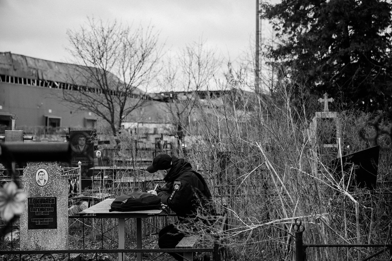 An officer draws up a report at the spot where Valentyna’s exhumation