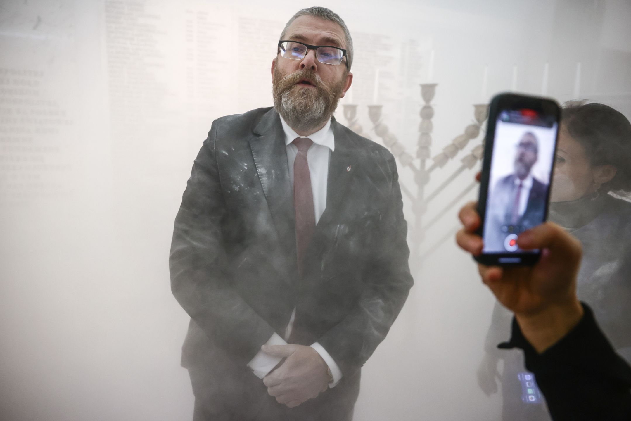 Grzegorz Braun, a member of the far-right Confederation party is seen after using a fire extinguisher on to put out candles on a menorah that was lit during Hannukah celebration in the parliament building in Warsaw, Poland on December 12, 2023.  (Photo by Beata Zawrzel/NurPhoto via Getty Images)