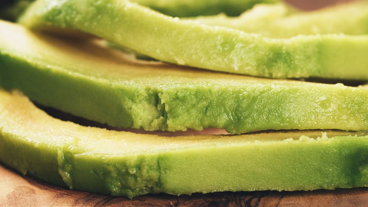 sliced ripe avocados on olive cutting boardsliced ripe avocados on olive cutting board, shallow focusGCapture