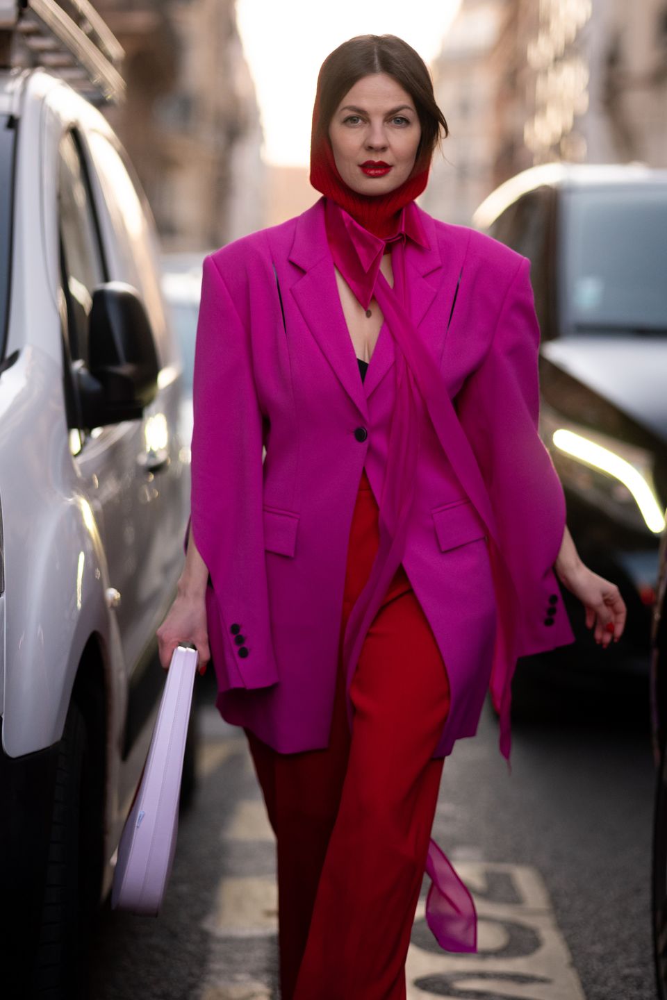 PARIS, FRANCE - MARCH 03: A guest wears a fuchsia blazer, red pants and red balaclava, outside Victoria Beckham, during Paris Fashion Week - Womenswear Fall Winter 2023 2024, on March 03, 2023 in Paris, France. (Photo by Claudio Lavenia/Getty Images)