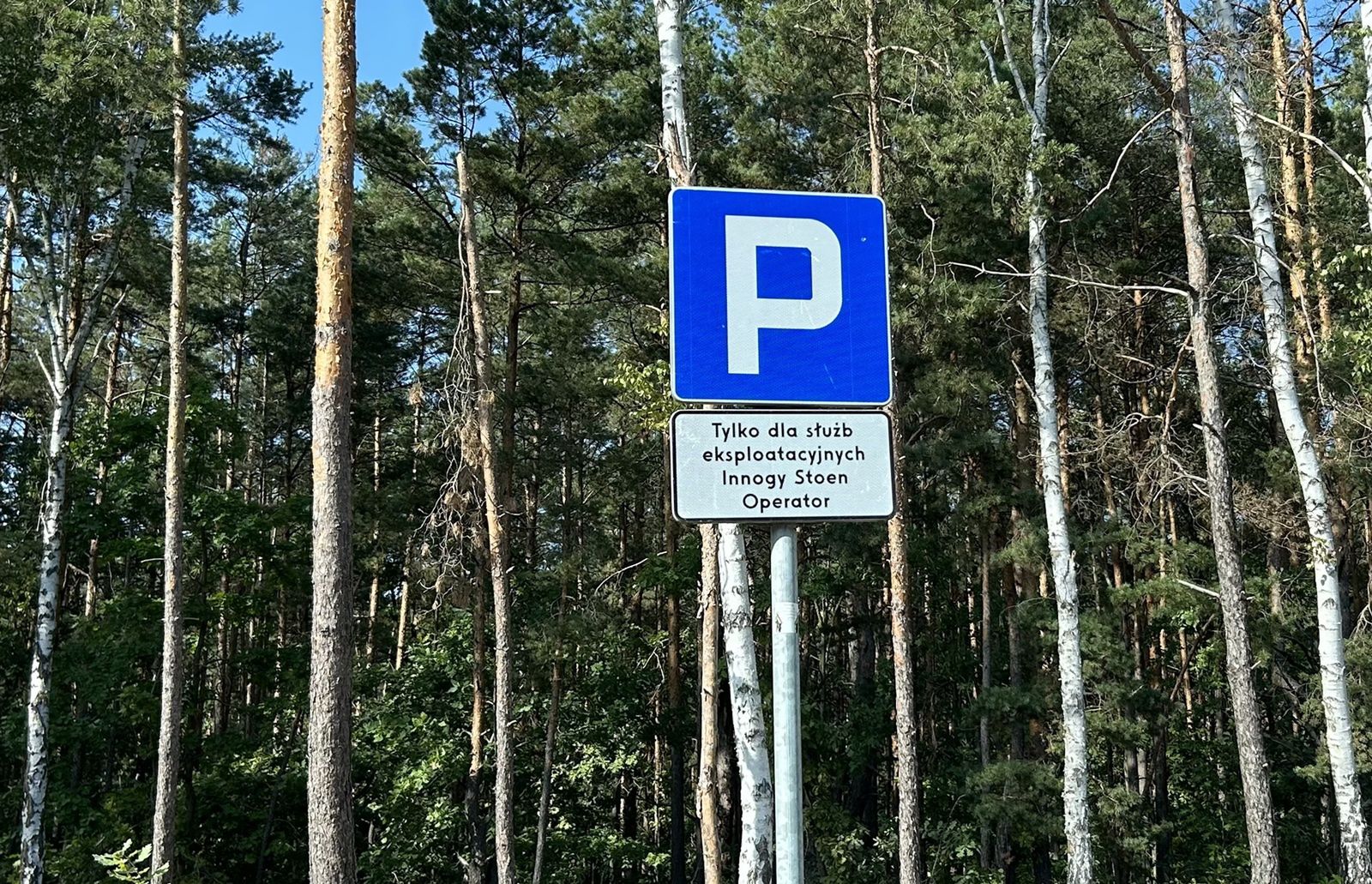 Tabliczka pod znakiem D-18, która nie budzi najmniejszych wątpliwości co do tego, kto może parkować na wyznaczonym miejscu. 