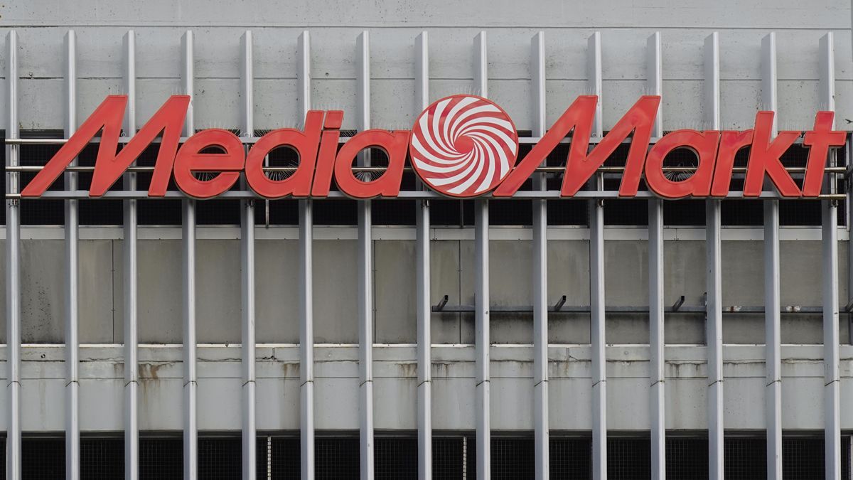 A large MediaMarkt logo is mounted on the facade of a concrete building with vertical metal bars in Munich, Bavaria, Upper Bavaria, Germany, on May 24, 2025. The bold red letters and the iconic swirl logo are prominently displayed above a weathered and industrial-looking surface. (Photo by Michael Nguyen/NurPhoto via Getty Images)