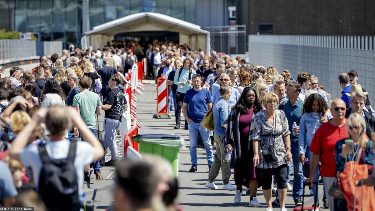 Podróżni czekają na wejście przed lotniskiem Schiphol 