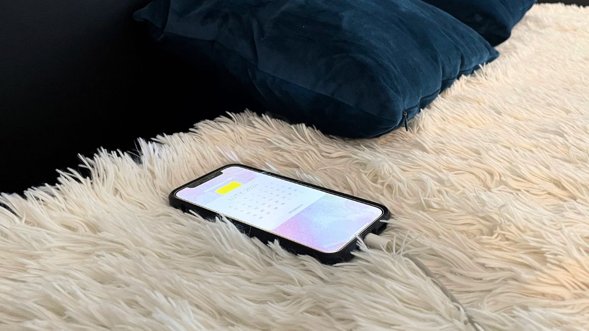 Telefon podpięty pod ładowarkę w sypialni