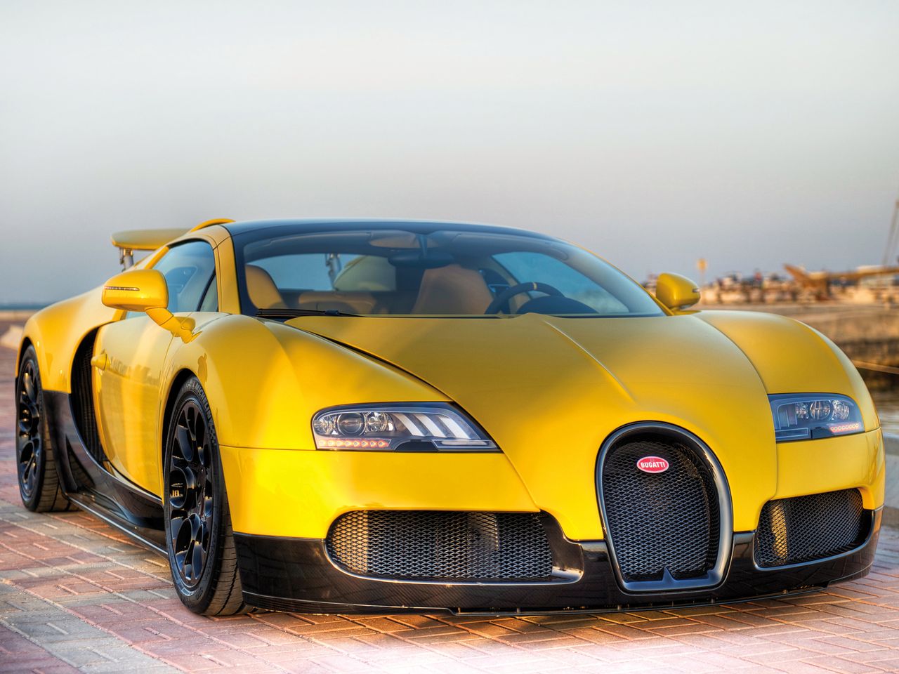 Bugatti przez cały okres produkcji Veyrona nie zapominało gdzie ma duże grono odbiorców. Dlatego powstała między innymi odmiana Middle East Edition. Łącznie zbudowano trzy egzemplarze tej serii. Pierwszy, który widzicie na zdjęciach został pokryty żółtym i czarnym lakierem. Sprzedano go za 1,58 mln euro. Nadwozie drugiego egzemplarza pokryto delikatnie transparentnym niebieskim lakierem, przez który było widać strukturę włókna węglowego. Do tego dołożono dodatki z polerowanego aluminium. Był w nie wyposażony także trzeci egzemplarz. Różnił się on kolorem prześwitującego lakieru. Był on zielony. Te dwa egzemplarze zostały sprzedane za 1,74 mln euro.