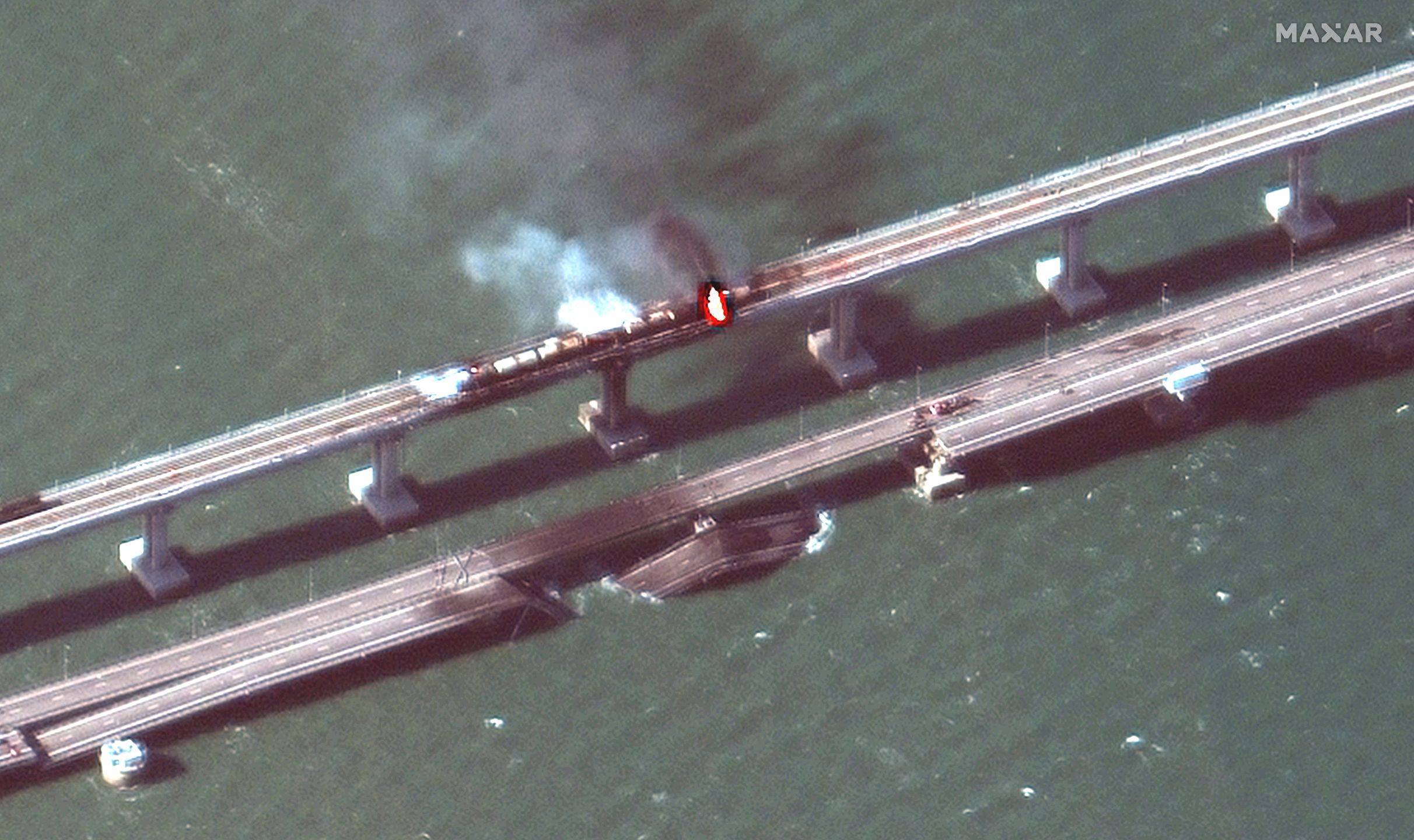 Parts of Crimea bridge collapse following fire
epa10231797 A handout satellite image made available by Maxar Technologies shows smoke and a collapsed part of the Kerch Strait bridge in Crimea, 08 October 2022. According to Russian authorities, 'an explosion was set off at a cargo vehicle on the motorway part of the Crimean bridge on the side of the Taman peninsula, which set fire to seven fuel tanks of a train that was en route to the Crimean peninsula. Two motorway sections of the bridge partially collapsed.'  EPA/MAXAR TECHNOLOGIES HANDOUT -- MANDATORY CREDIT: SATELLITE IMAGE 2022 MAXAR TECHNOLOGIES -- THE WATERMARK MAY NOT BE REMOVED/CROPPED -- HANDOUT EDITORIAL USE ONLY/NO SALES HANDOUT EDITORIAL USE ONLY/NO SALES HANDOUT EDITORIAL USE ONLY/NO SALES 
Dostawca: PAP/EPA.
MAXAR TECHNOLOGIES HANDOUT