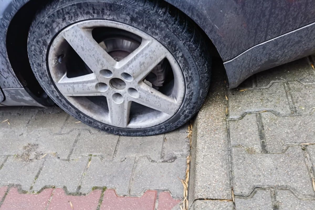 Uszkodzona opona w wyniku najechania na dziurę w jezdni na al. Andersa