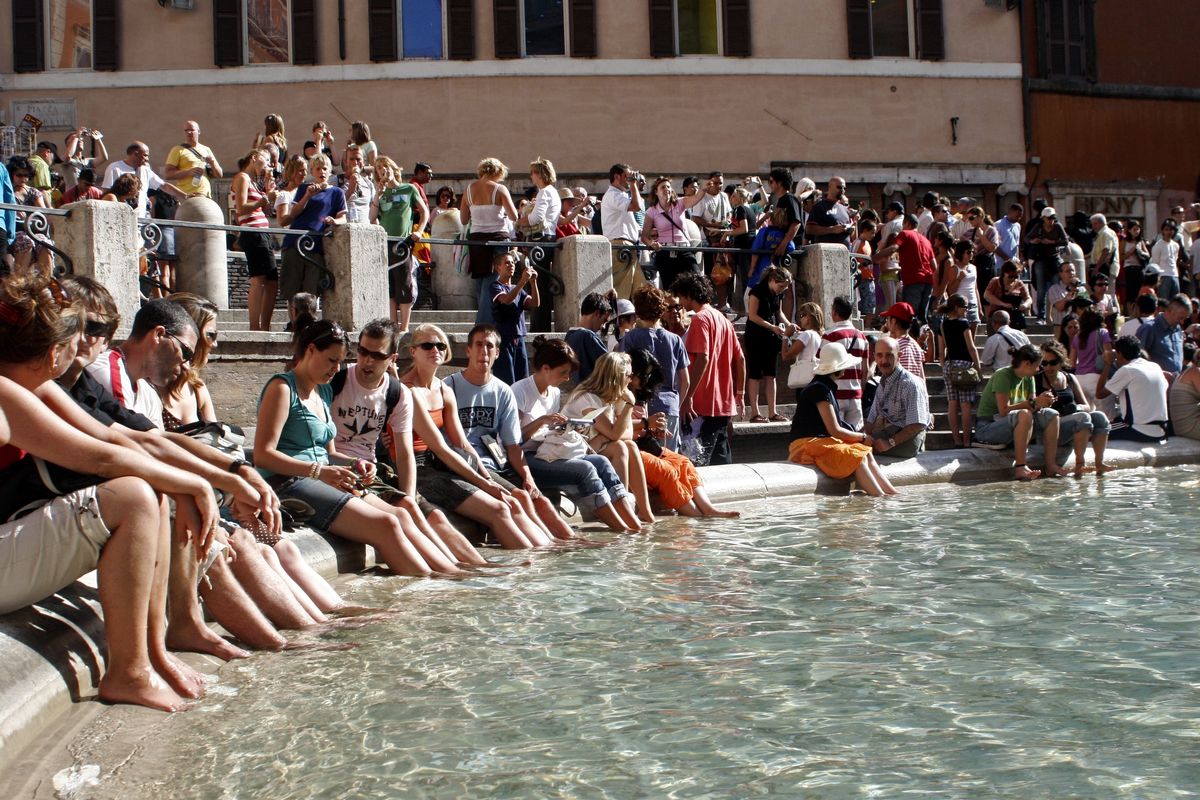 Grupa turystów odpoczywa przy Fontannie di Trevi w Rzymie