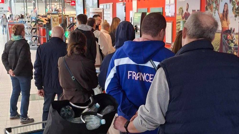 Kolejka ludzi do zwrotu butelek 