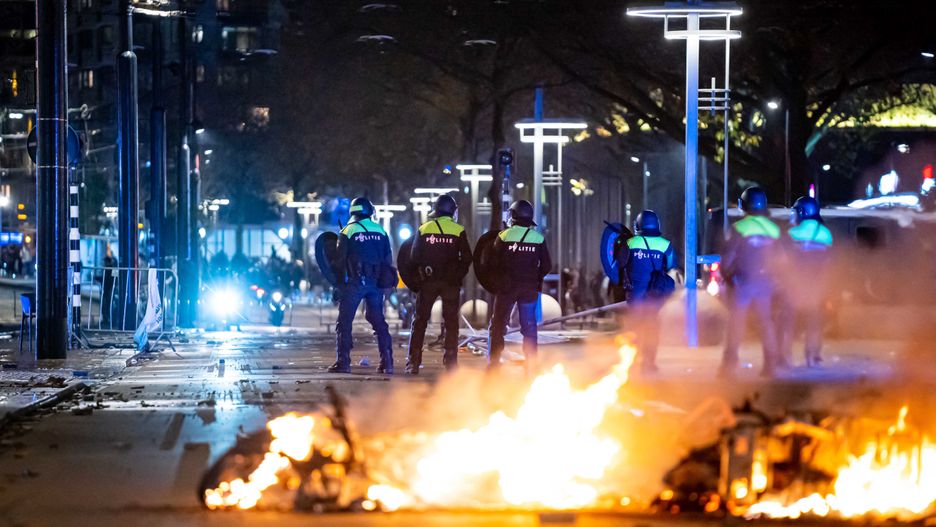 epa09593019 Policemen stand near burning objects after a protest against the '2G policy' turned into riots, with protesters setting fires in the street and destroying police cars and street furniture, Rotterdam, Netherlands, 19 November 2021. Hundreds of demonstrators gathered on Coolsingel earlier that evening because they disagree with the 2G policy, which refers to the two Dutch words for vaccinated and recovered.  EPA/VLN NIEUWS Dostawca: PAP/EPA.