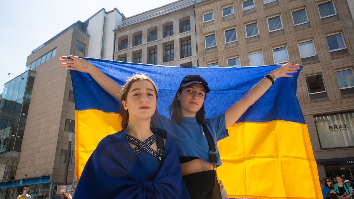 two protesters hold a Ukrain flags are seen during the march of anti war protest against Russian invasion of Ukraine in Dueseldorf, Germany on July 24, 2022 (Photo by Ying Tang/NurPhoto via Getty Images)