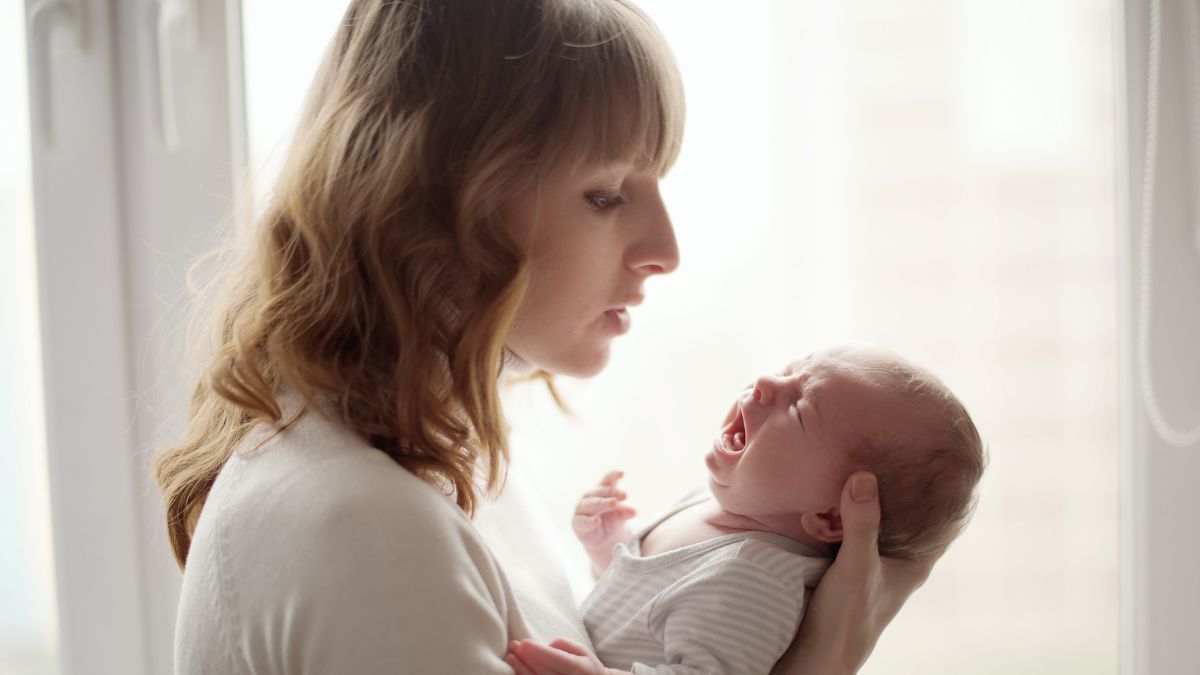 Mama uspokaja płaczące dziecko.