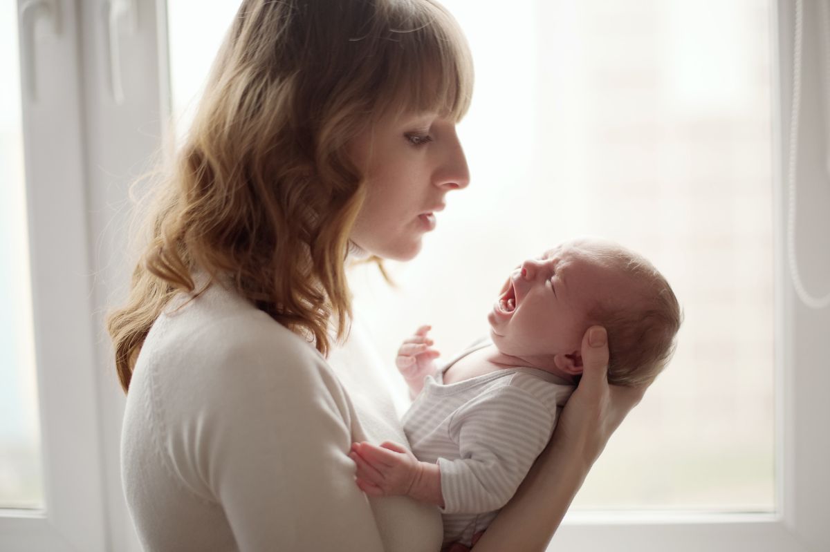 Mama uspokaja płaczące dziecko.