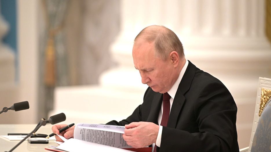 MOSCOW, RUSSIA - FEBRUARY 21: (----EDITORIAL USE ONLY â MANDATORY CREDIT - "KREMLIN PRESS OFFICE / HANDOUT" - NO MARKETING NO ADVERTISING CAMPAIGNS - DISTRIBUTED AS A SERVICE TO CLIENTS----) President of Russia, Vladimir Putin signs decrees on the recognition of the self-proclaimed Donetsk People's Republic (DPR) and the Luhansk People's Republic (LPR) in Moscow, Russia on February 21, 2022. The heads of the self-proclaimed Donetsk People's Republic (DPR) and the Luhansk People's Republic (LPR) asked the President of Russia to recognize the self-proclaimed republics. This issue was discussed at a meeting of the Security Council of the Russian Federation, Vladimir Putin appealed to the Federal Assembly of the Russian Federation to ratify the treaty of friendship and mutual assistance with the DPR-LPR. Putin signed decrees on the recognition of the self-proclaimed Donetsk People's Republic (DPR) and the Luhansk People's Republic (LPR). (Photo by Kremlin Press Office / Handout/Anadolu Agency via Getty Images)