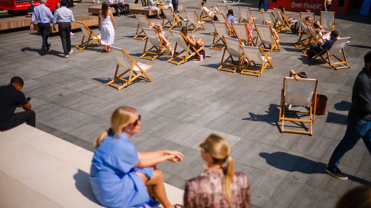 City workers sit on deck chairs in a square during lunch hour in the City of London, UK, on Monday, Aug. 12, 2024. In northwest Europe, London, Paris and Berlin are set for their hottest day of the season, according to Weather Services International. Photographer: Jose Sarmento Matos/Bloomberg via Getty Images