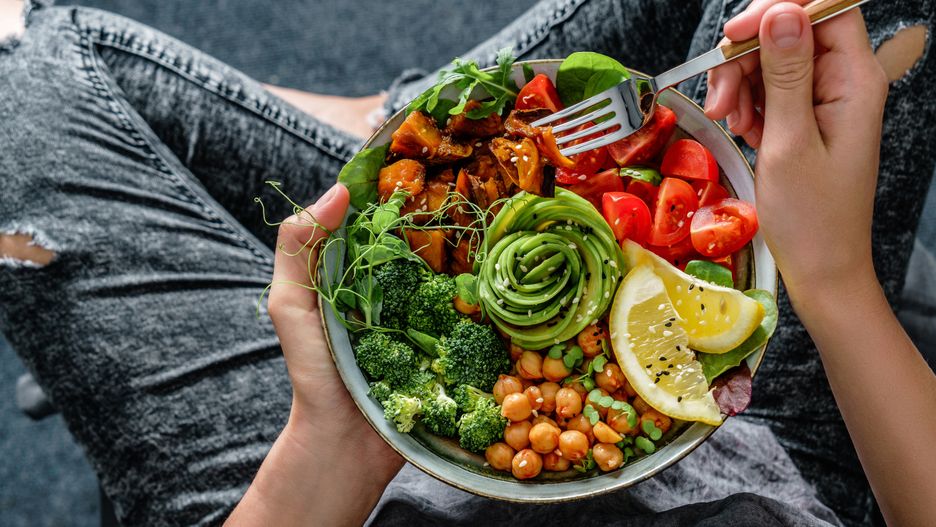 Woman in jeans holding Buddha bowl with salad, baked sweet potatoes, chickpeas, broccoli, greens, avocado, sprouts in hands. Healthy vegan food, clean eating, dieting, top viewhands, background, quinoa, chickpeas, sweet potato, buddha bowl, sprouts, tomatoes, avocado rose, alkaline diet, broccoli, clean eating, close up, flat lay, food, fresh, green, healthy, hummus, ingredient, salad, superbowl, appetizer, breakfast, cooking, detox, diet, dieting, dinner, eating, healthy food, lifestyle, lunch, meal, nutrition, organic, plate, superfood, table, top view, vegan, vegetable, vegetarian, veggie, sesame, woman, holding, female, jeans, person
