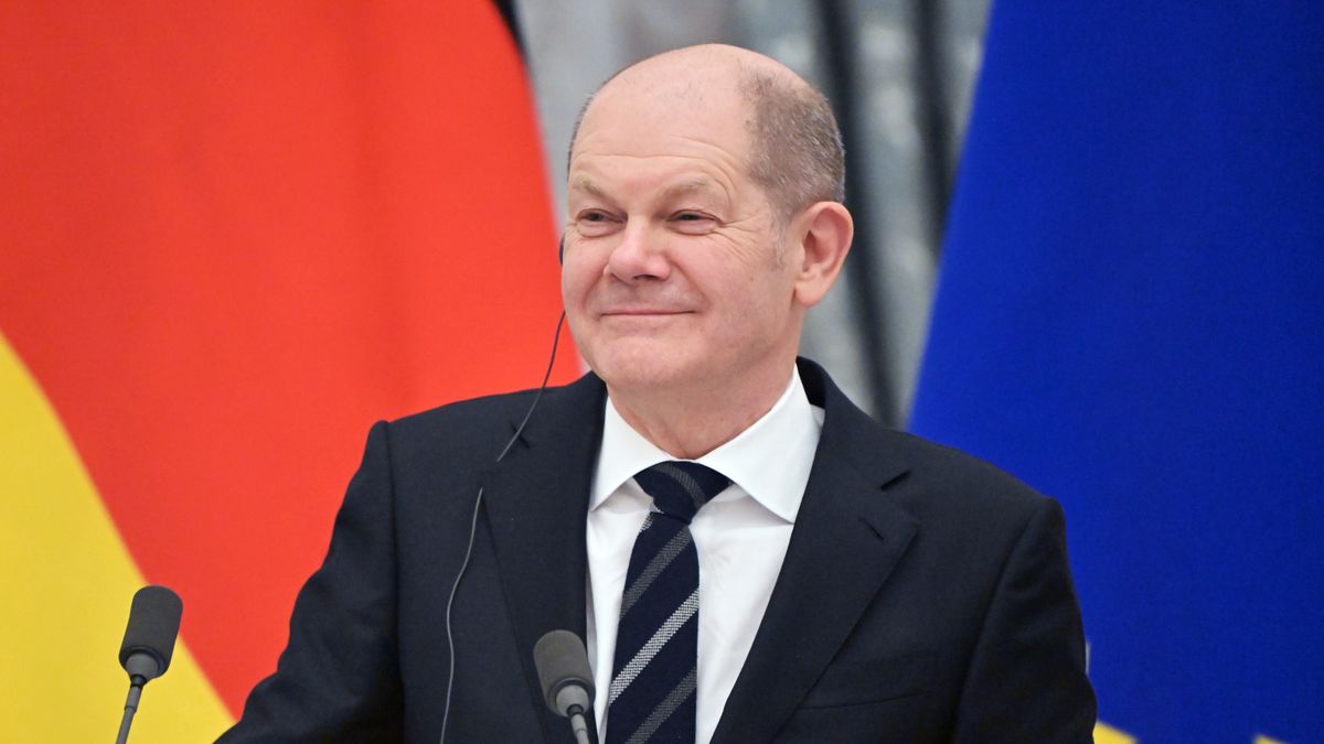 Na zdjęciu kanclerz Niemiec Olaf Scholz na tle flag niemieckiej i unijnej