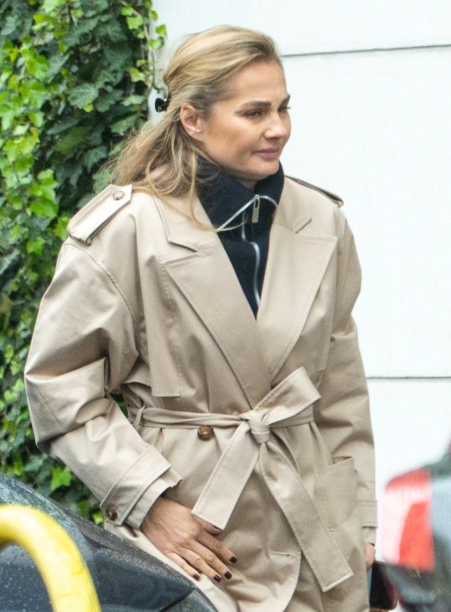 Małgorzata Socha maszeruje po deszczowej Warszawie ze smartfonem przy uchu