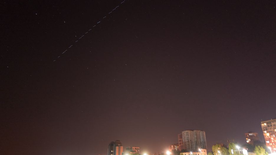 ZAPORIZHZHIA, UKRAINE - SEPTEMBER 14: A constellation of Elon Musk's SpaceX Starlink satellites fly above Zaporizhzhia as local residents fish at night on the Dnipro River on September 14, 2023 in Zaporizhzhia, Ukraine. (Photo by Pierre Crom/Getty Images)