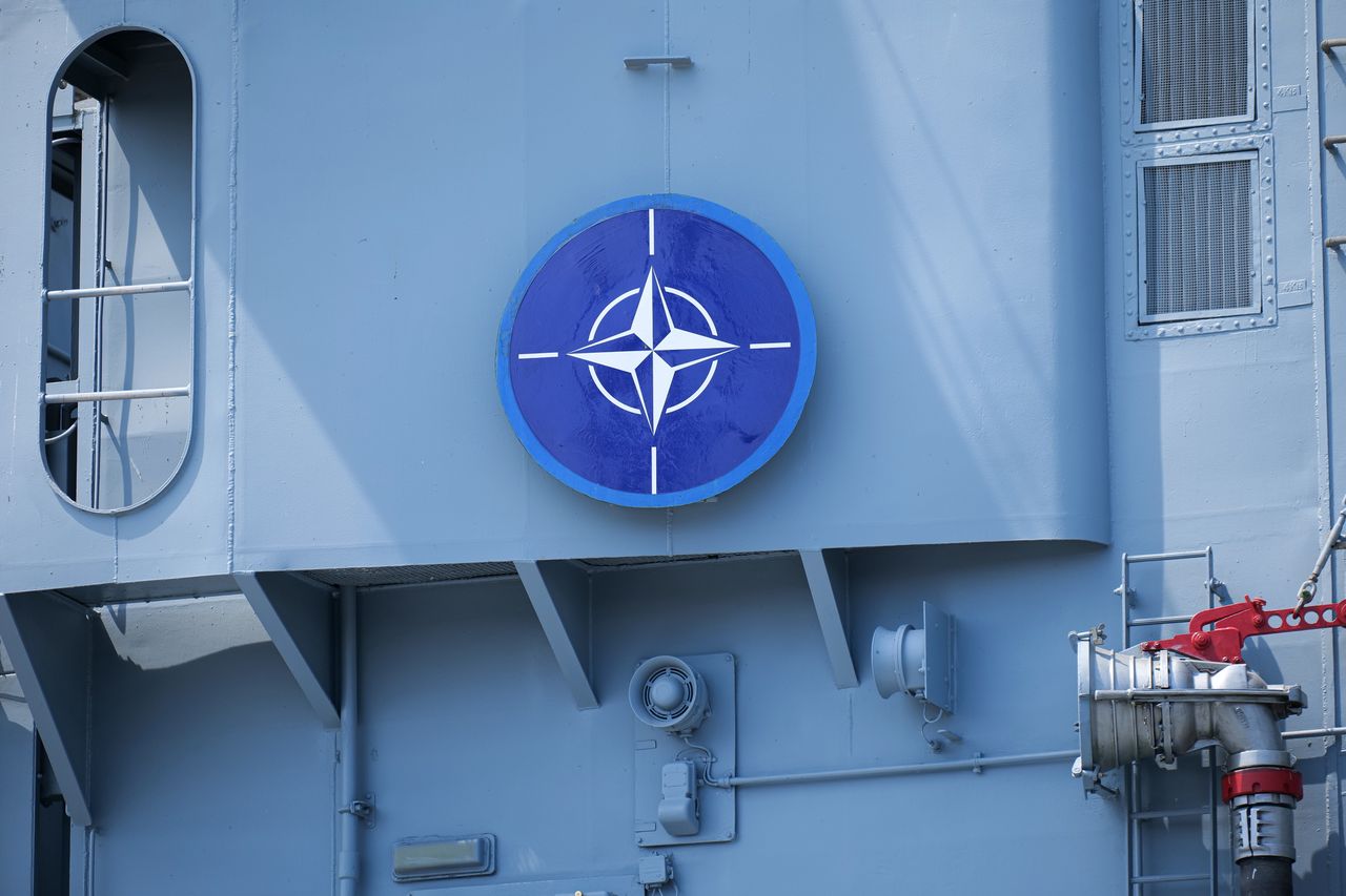 The logo of NATO on a military vessel ship.