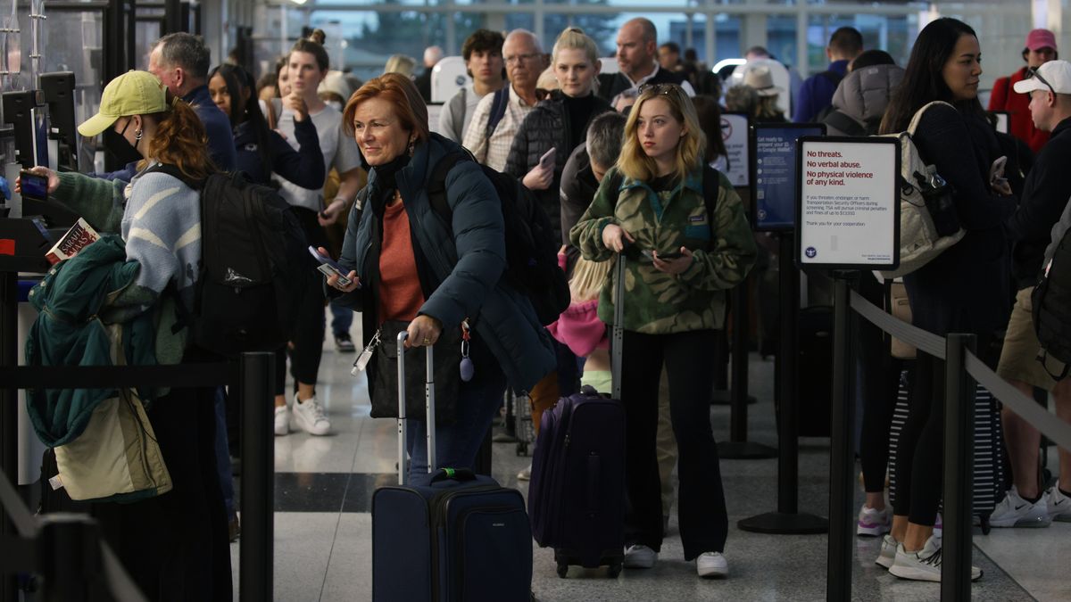 ARLINGTON, VIRGINIA - NOVEMBER 21: Passengers wait in-line for going through security check at Ronald Reagan Washington National Airport on November 21, 2023 in Arlington, Virginia. AAA predicted that at least 55 million people will travel more than 50 miles for the Thanksgiving holiday. (Photo by Alex Wong/Getty Images)