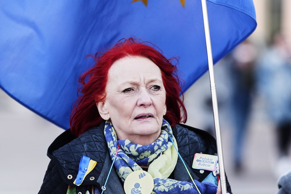 A group of elderly women calling themsleves the 'Angry Grandmothers' is seen arriving near the Royal Castle holding Ukrainian and European Union flags on March 26, 2022 in Warsaw, Poland. President Biden spent his second day in Warsaw on Saturday visiting refugees from Ukraine in the National Stadium with Rafal Trzaskowski, the mayor of Warsaw and the Polish Prime Minister Mateusz Morawiecki. President Biden also gave a fiery speech against the Russian invasion of Ukraine while assuring that NATO will defend all its member states against any aggression at all costs. (Photo by STR/NurPhoto via Getty Images)