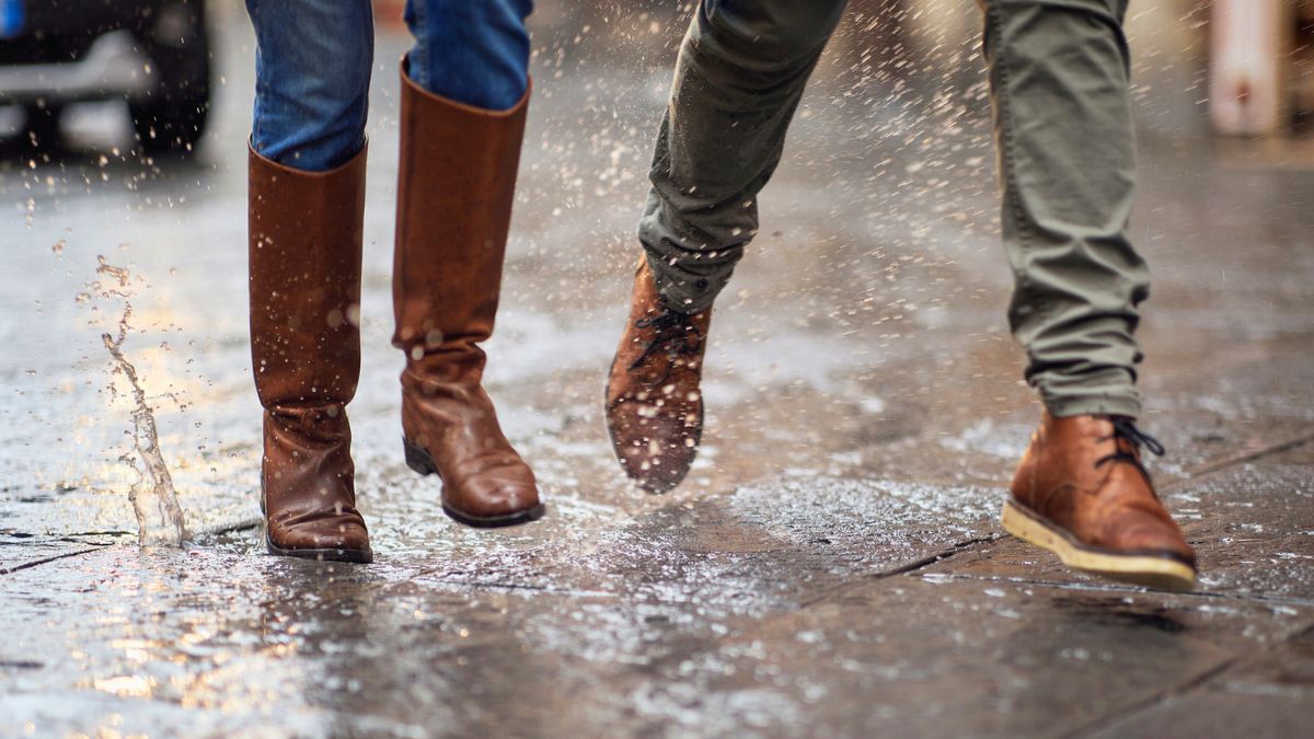 Mężczyzna i kobieta chodzą po mokrej ulicy