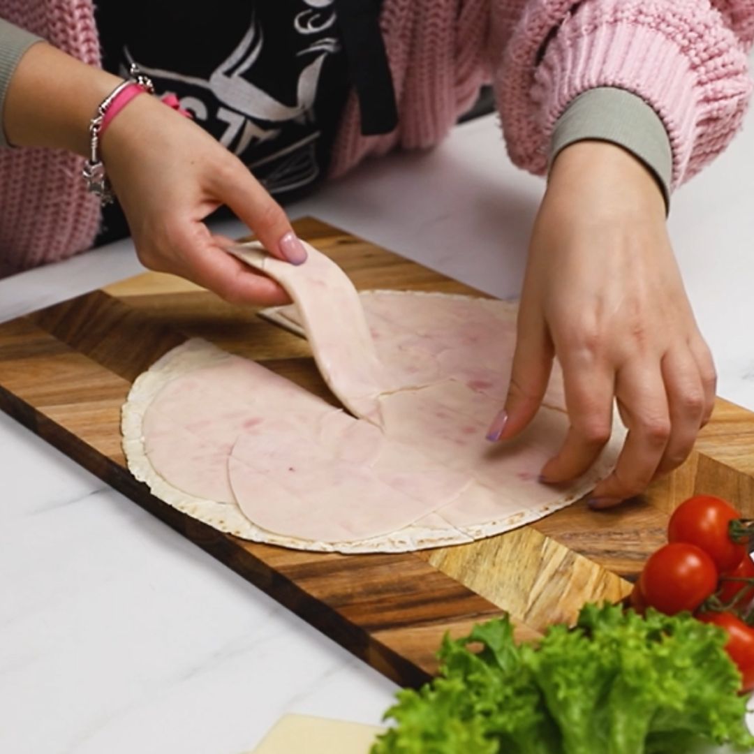 I divide the flatbread with toppings into smaller parts.