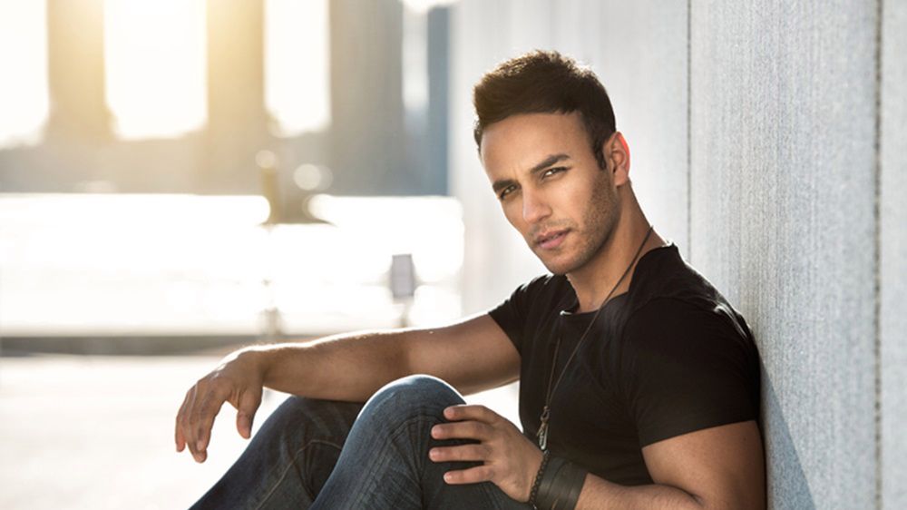 W modnych ciemnych jeansach oraz t-shircie podkreślającym muskuły mężczyzna przyciąga kobiecy wzrok