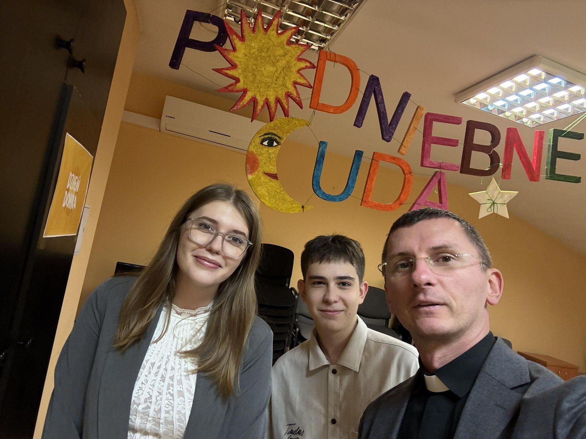 Od lewej: Dawid Bartosiński, Klaudia Wleciał, uczniowie pińczowskiego &#34;Kołłątaja&#34; oraz ksiądz Tomasz Kaczówka ich katecheta podczas wizyty w Hospicjum Caritas imienia świętej Matki Teresy z Kalkuty w Kielcach. 12 października 2025. 