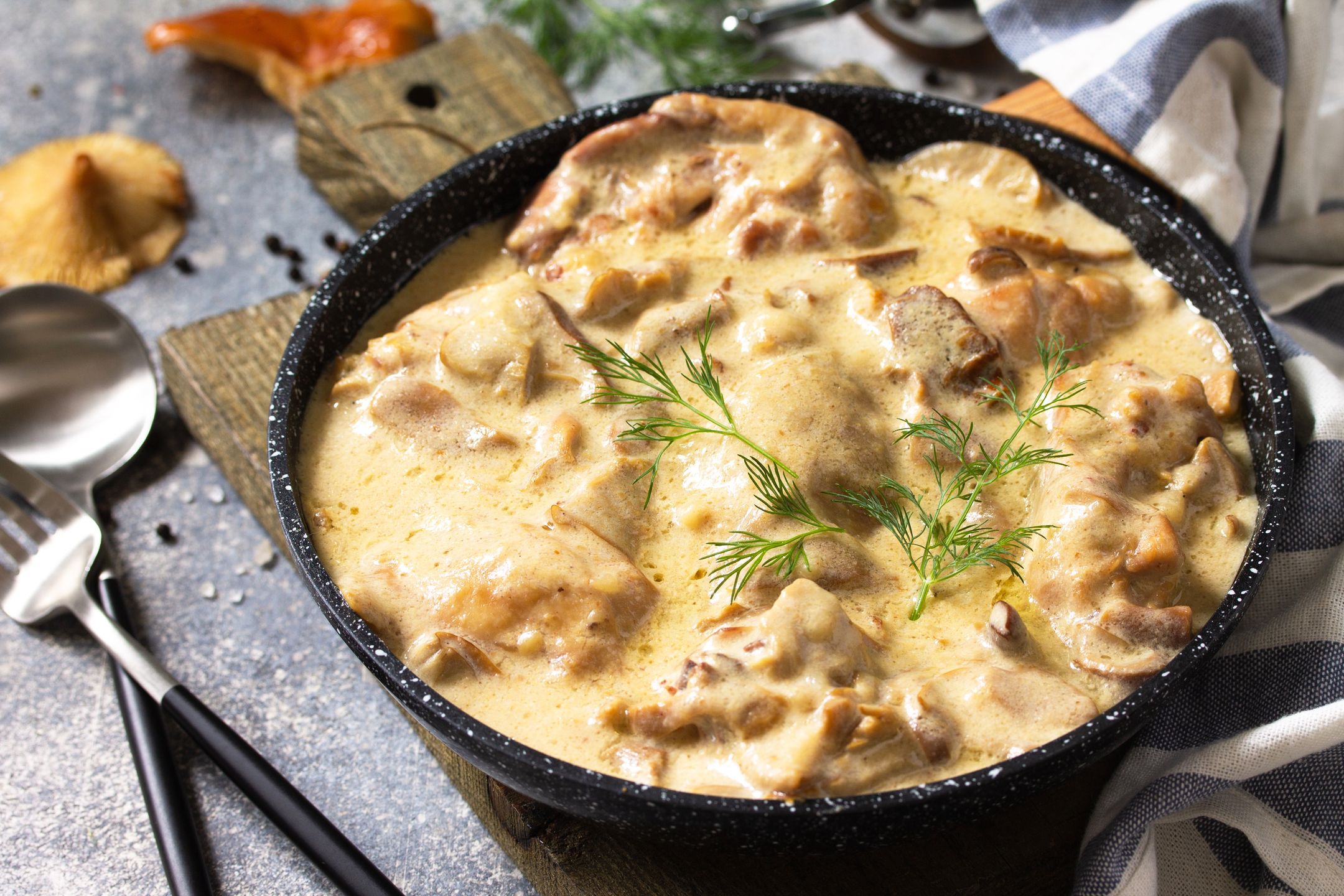 Fricasse - French Cuisine. Chicken stewed in a creamy sauce with mushrooms in a pan on a light stone background. fricasse, chicken, champignon, filet, grill, culinary, red mushroom, cuisine, frying, homemade, bechamel, mustard, morning sauce, healthy, white sauce, turkey, lunch, meal, cream, meat, dish, meal, dinner, cuisine, french cooking, stew, poultry, vegetable, sauce, recipe, stew, wooden, closeup, homemade, green, garlic, table, mushroom, eat, seasonings, rustic, vegetables, hot, frying pan, thanksgiving, table menu, stroganoff