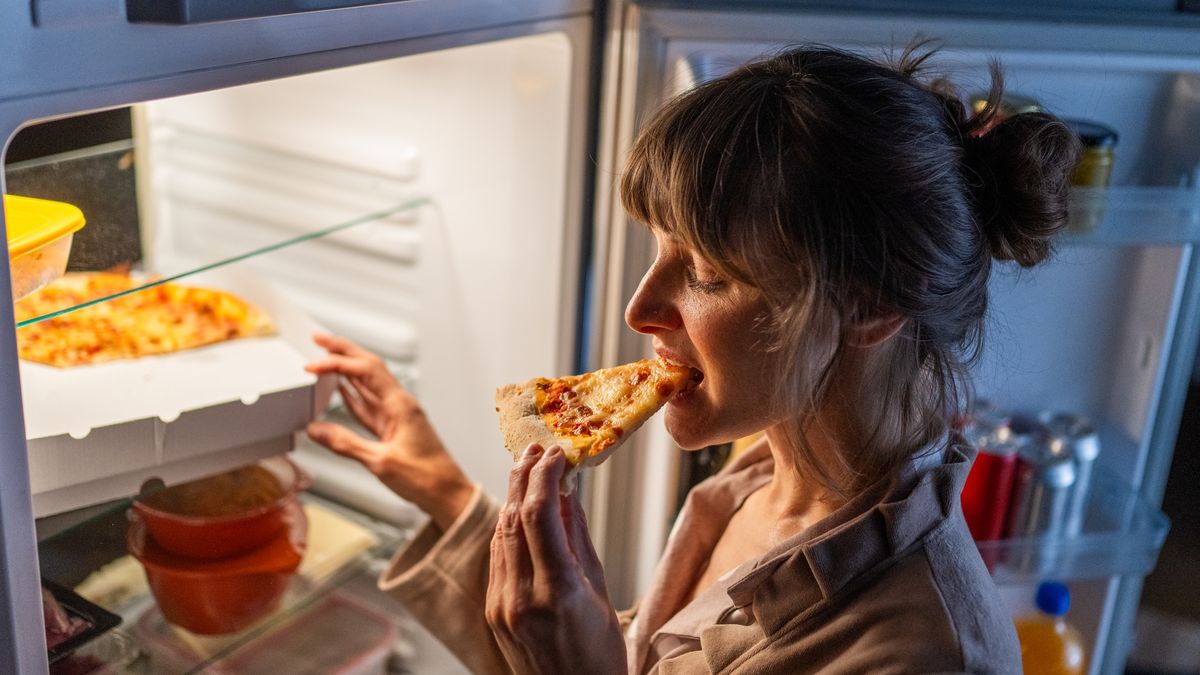 Woman eating pizza
Mature woman eating pizza while standing near open refrigerator at home.
simonkr