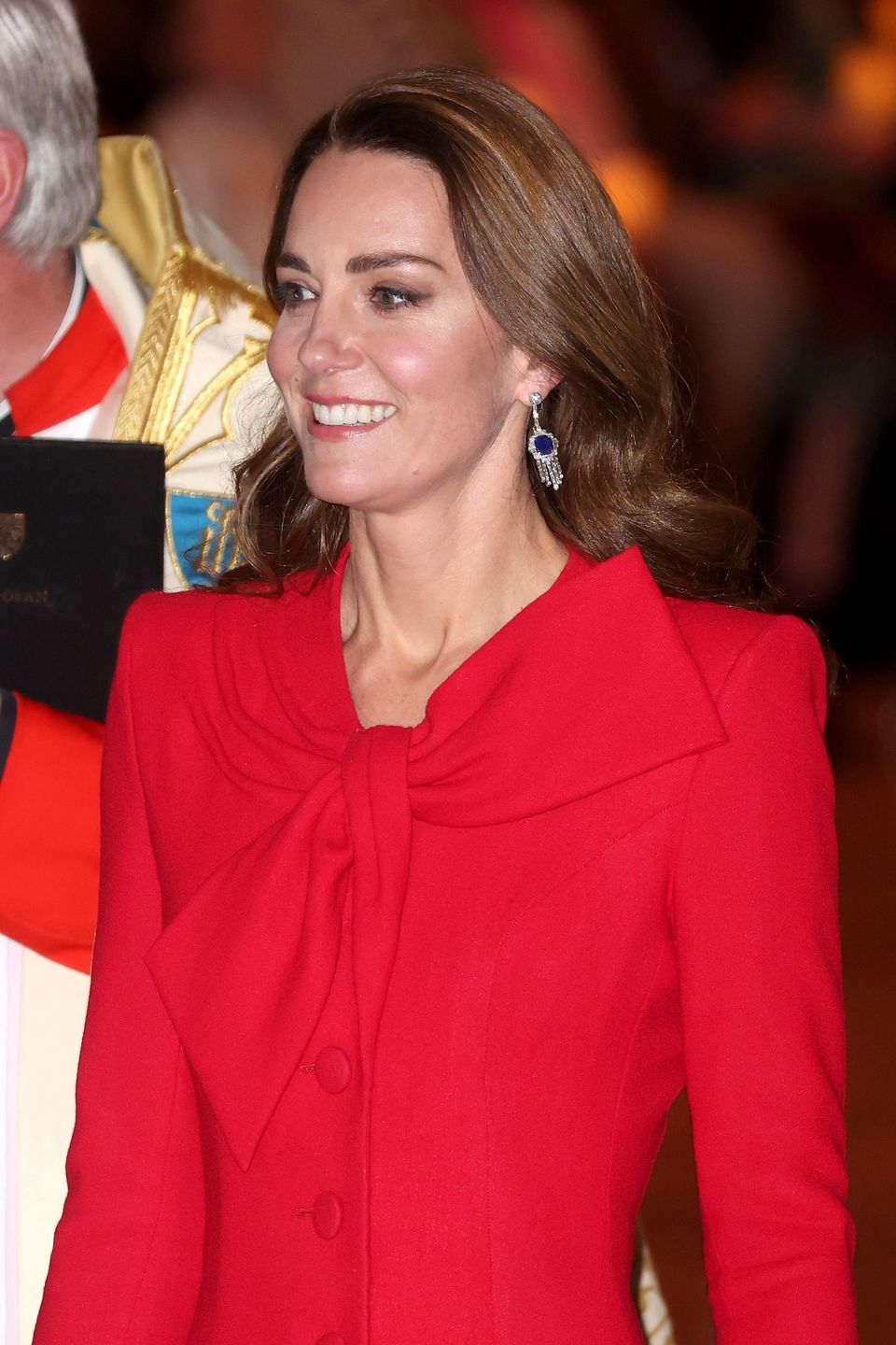 Kate Middleton w czerwonej sukience-płaszczu kolęduje z księciem Williamem