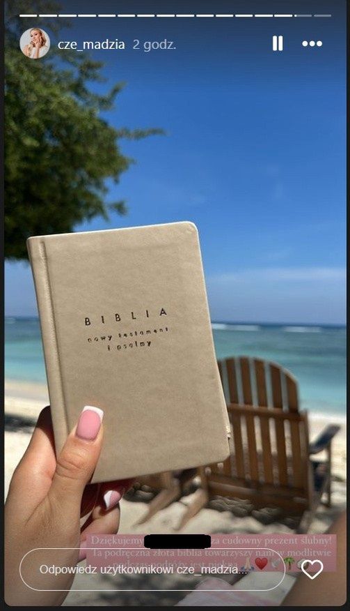 Żona Rafała Mroczka czyta Biblię na plaży