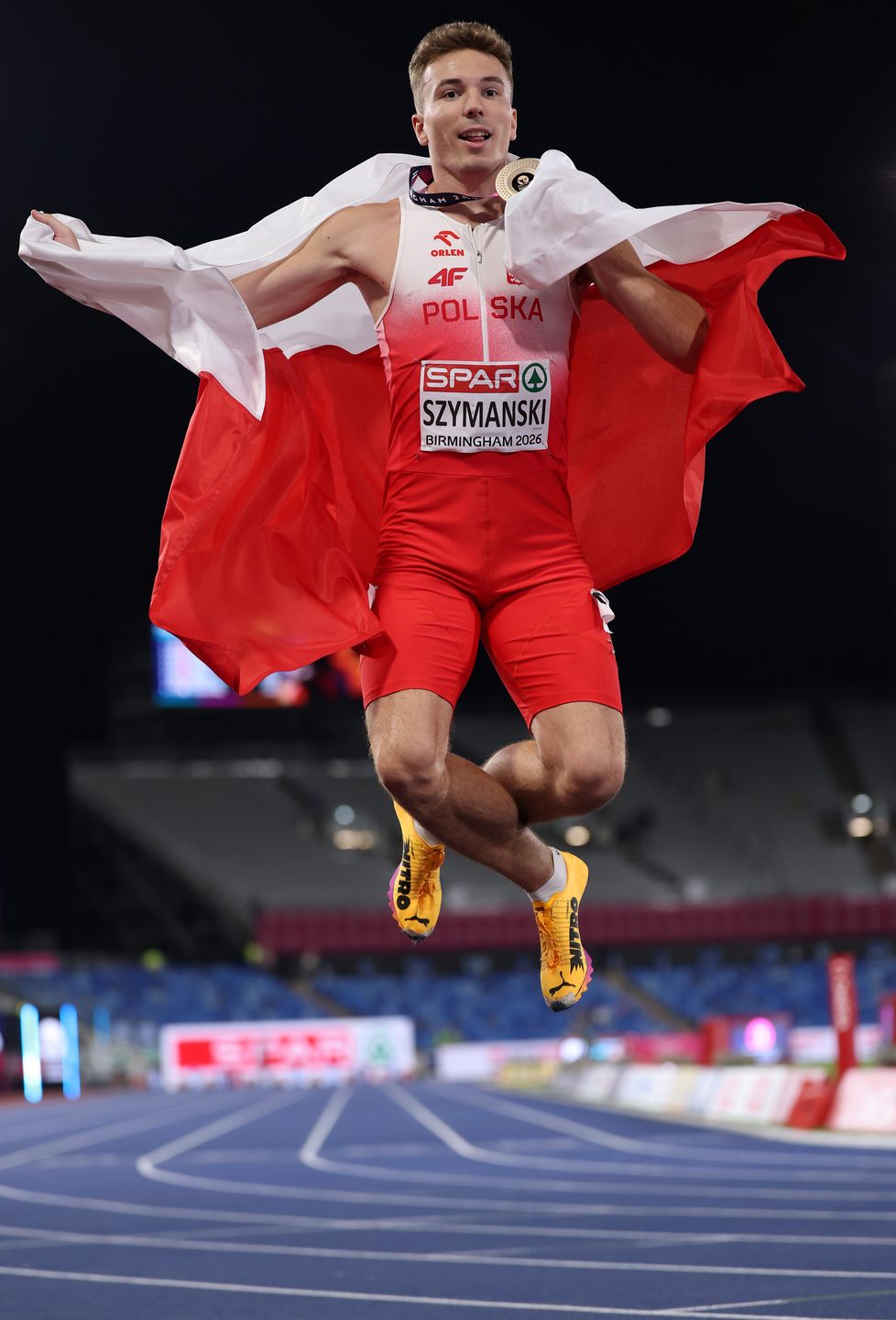 BIRMINGHAM, ENGLAND - AUGUST 12: Bronze medalist Jakub Szymanski of Team Poland poses for a photo with the national flag after the Men's 110 Metres Hurdles Final during day three of the 27th European Athletics Championships at Alexander Stadium on August 12, 2026 in Birmingham, England. (Photo by Julian Finney/Getty Images)