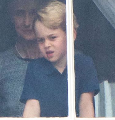 Księżniczka Charlotte i książę George stroją miny w oknie Pałacu Buckingham