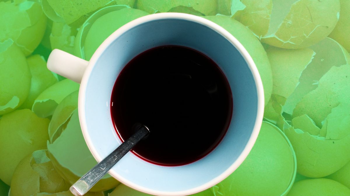 A cup of coffee with a red liquid in it looked at from above.