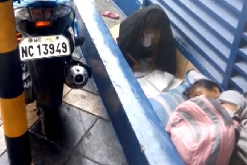 Bezdomna dziewczynka z Manili odrabia lekcje w strugach deszczu