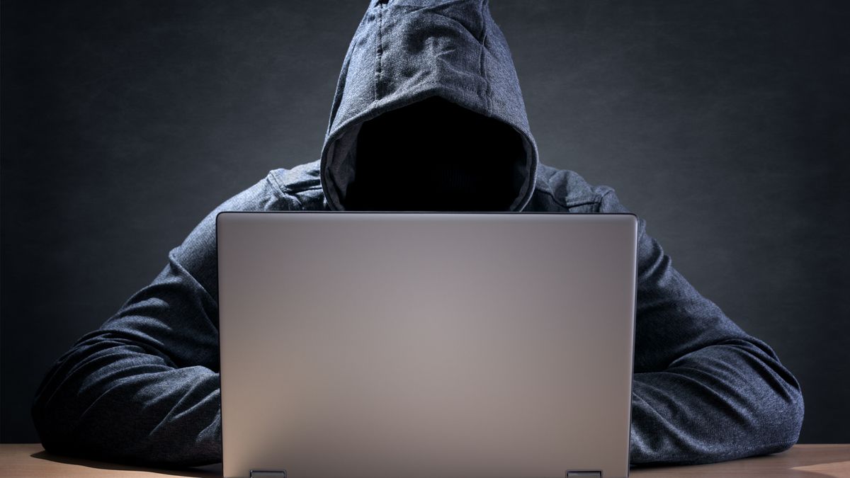 Computer hacker stealing data from a laptop concept for network security, identity theft and computer crime