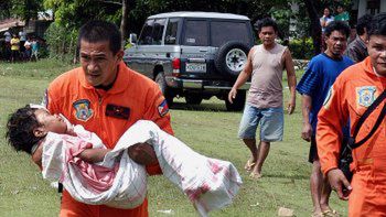 Ratownik niesie jedną z ofiar kataklizmu