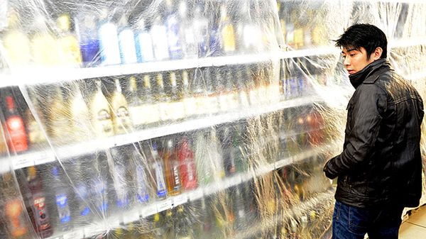 Klient czeskiego sklepu przygląda się zasłoniętej półce pełnej wysokoprocentowych alkoholi