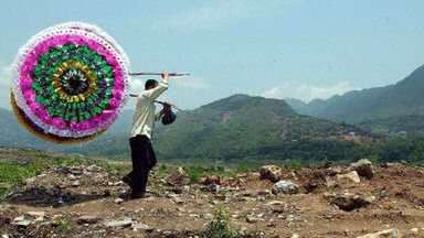 Mężczyzna niesie papierowe kwiaty na pogrzeb w mieście Wushan, które być może zostanie zalane przy budowie tamy