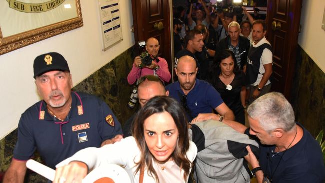Policja wyprowadza podejrzanego o gwałt na Polce w Rimini. 