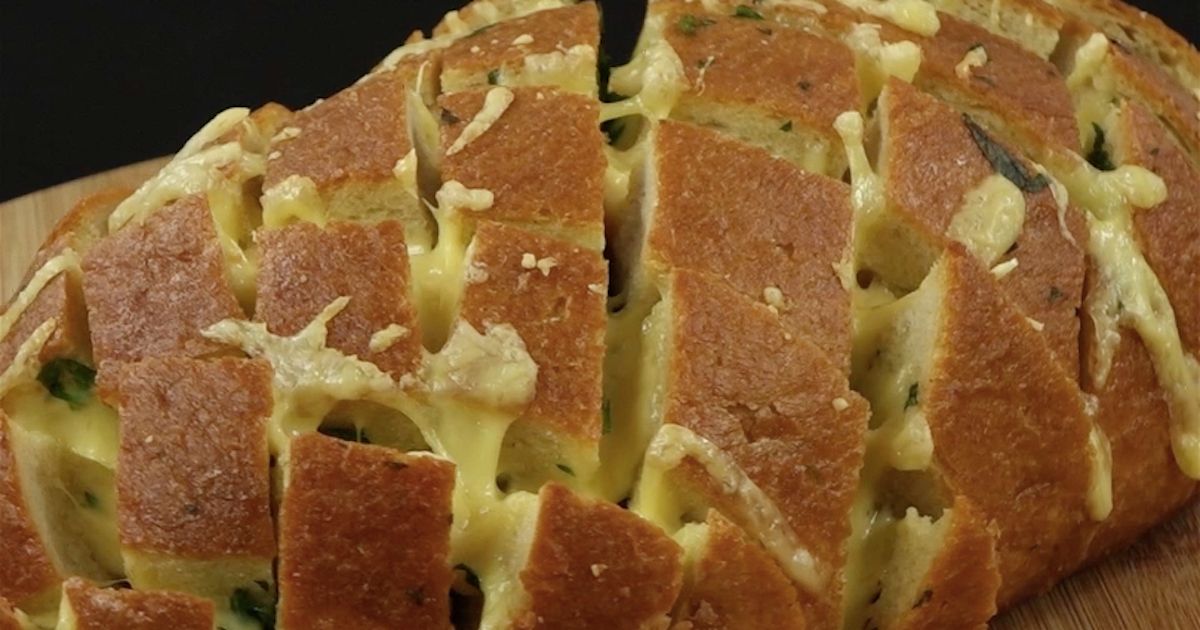 Pieczony chleb faszerowany masłem, czosnkiem, pietruszką i żółtym serem