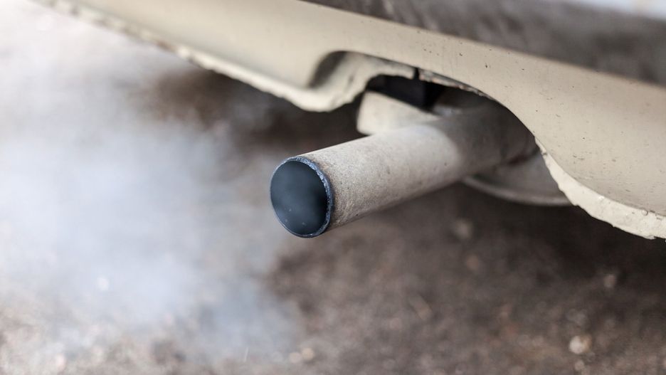 Combustion fumes coming out of car exhaust pipe