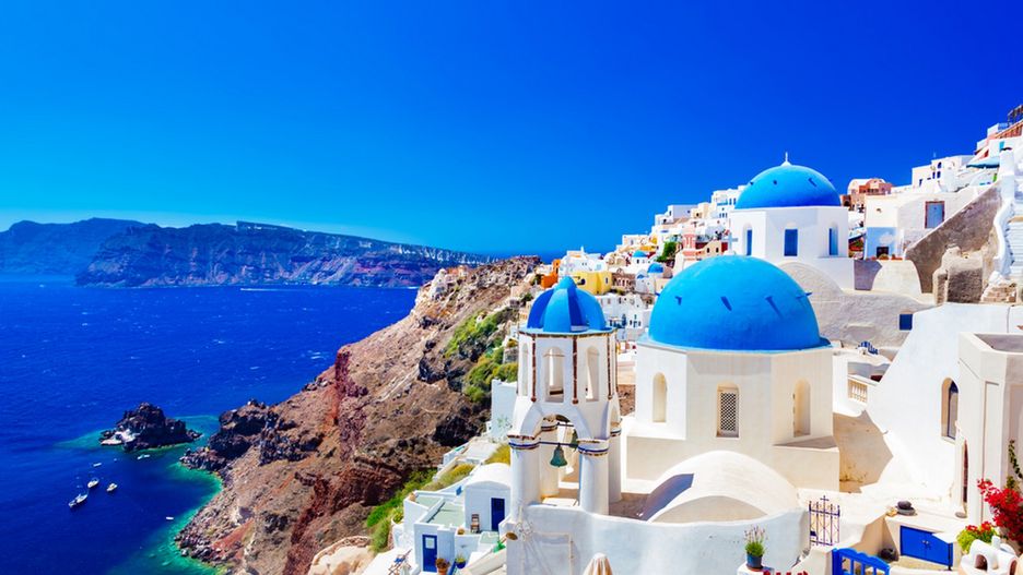 Na Santorini biel domów aż lśni na tle czystego nieba i niebieskiej powierzchni morza