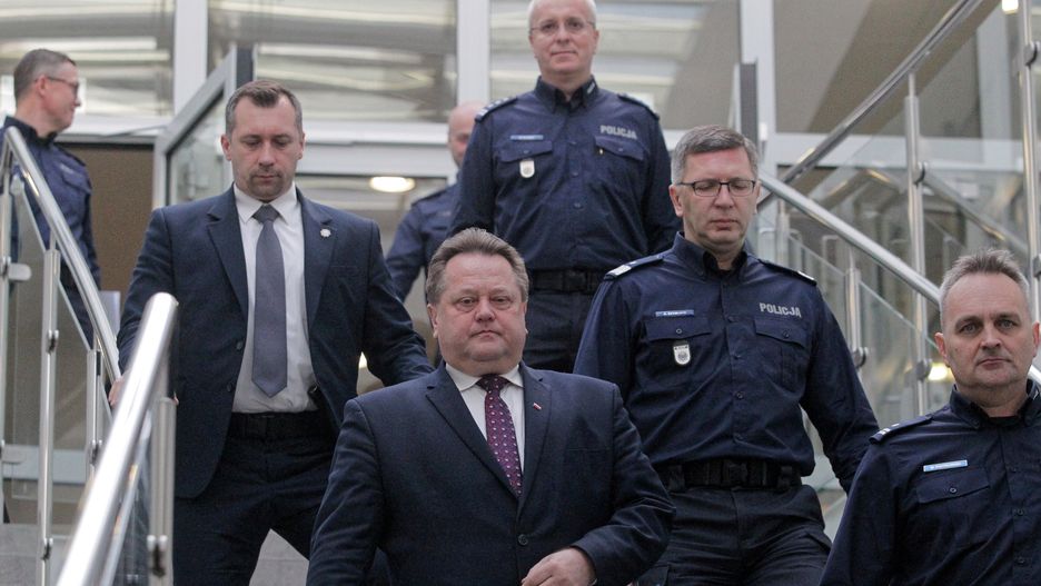 Jarosław Zieliński w otoczeniu ochrony i policjantów